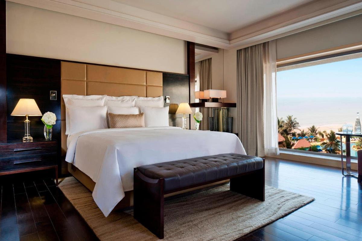 a bedroom with a large bed and a large window at JW Marriott Mumbai Juhu in Mumbai