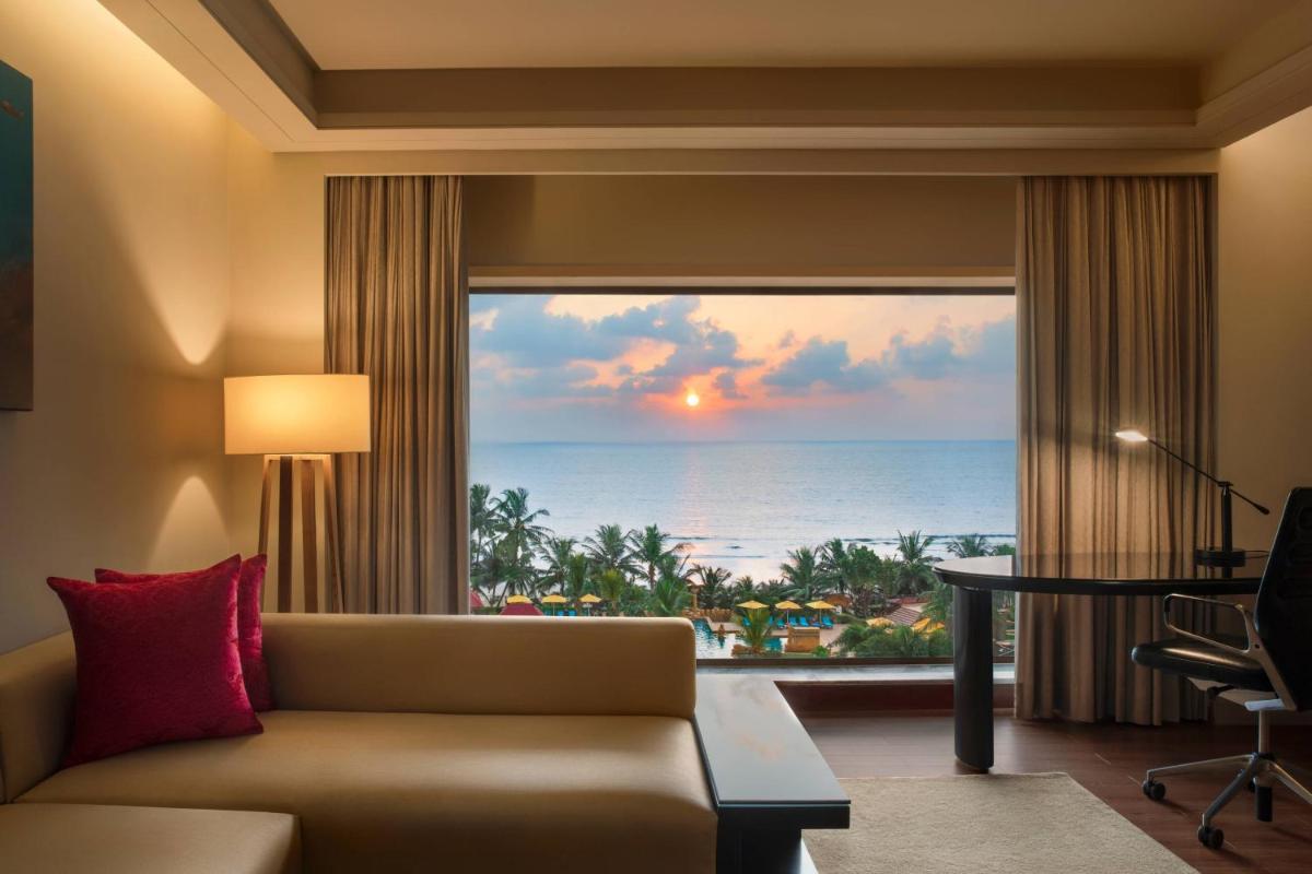 a living room with a couch and a view of the ocean at JW Marriott Mumbai Juhu in Mumbai