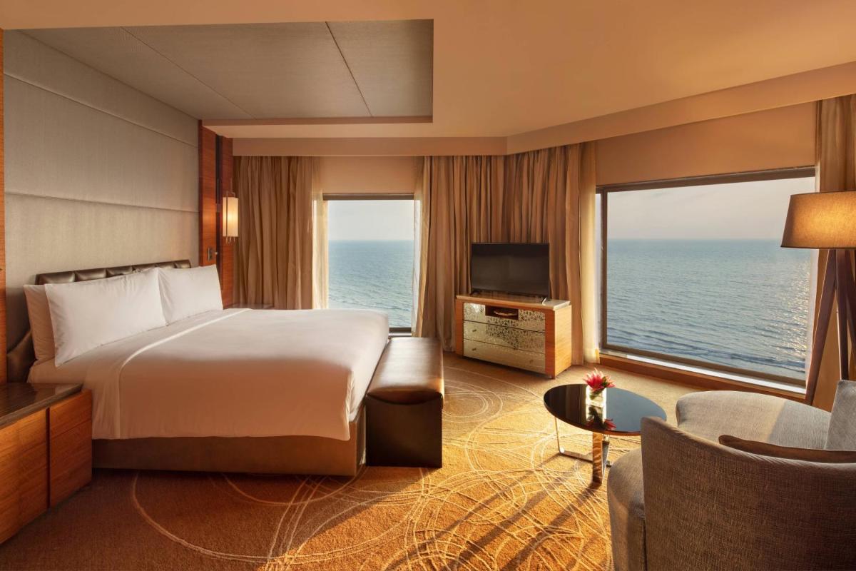 a hotel room with a bed and a view of the ocean at JW Marriott Mumbai Juhu in Mumbai
