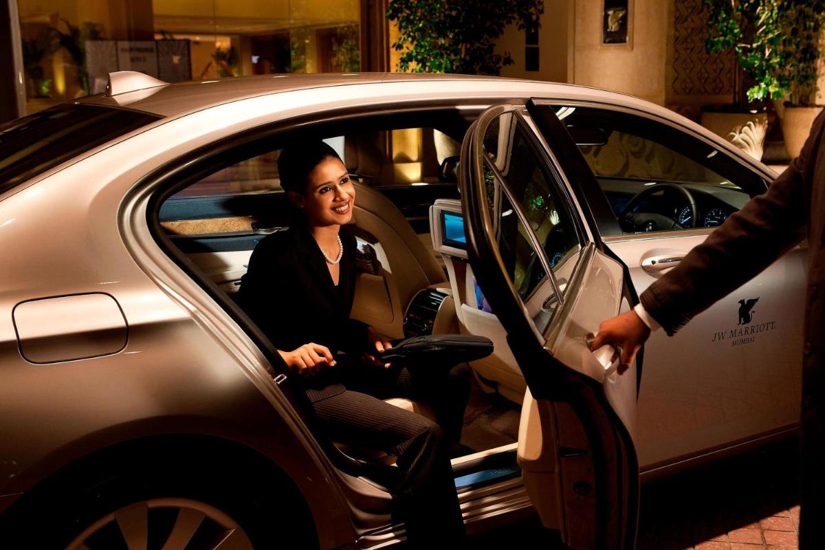 a woman sitting inside of a car with a person at JW Marriott Mumbai Juhu in Mumbai