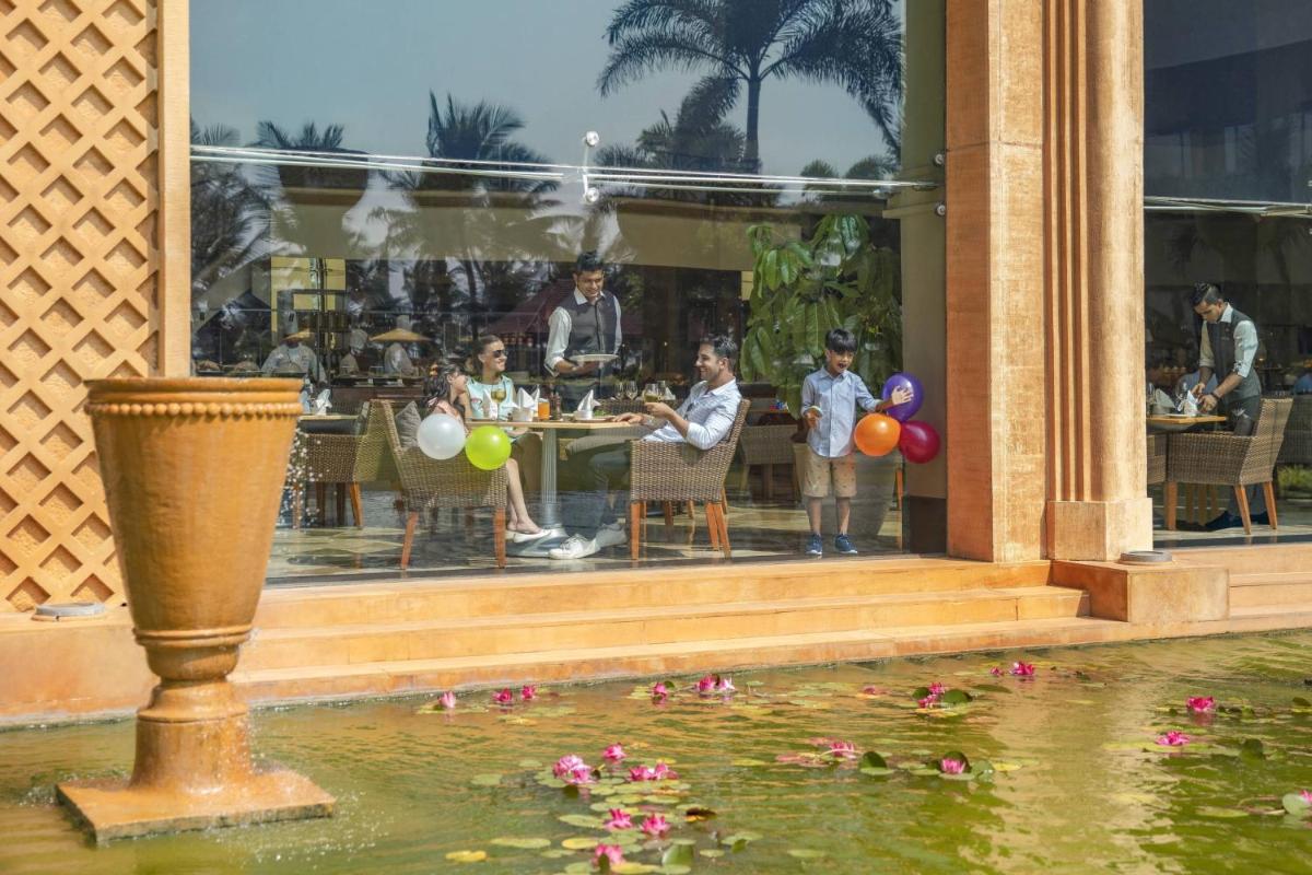 a group of people sitting at a table in a restaurant at JW Marriott Mumbai Juhu in Mumbai