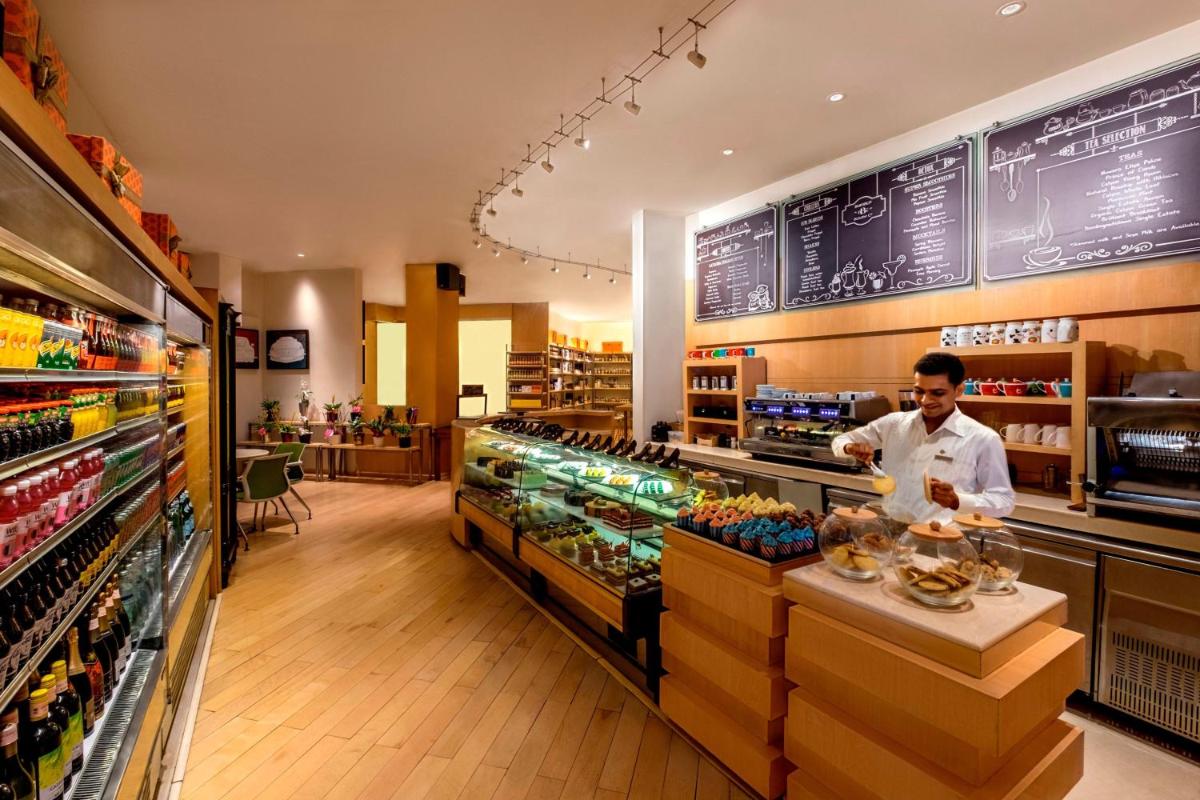 a man standing behind a counter in a supermarket at JW Marriott Mumbai Juhu in Mumbai