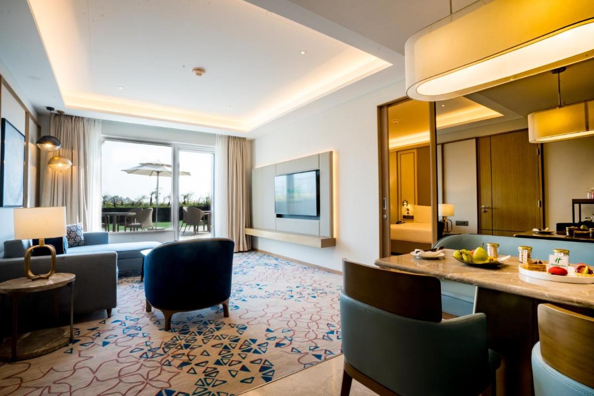 a hotel lobby with a living room and a dining area at Holiday Inn Lucknow Airport by IHG in Lucknow