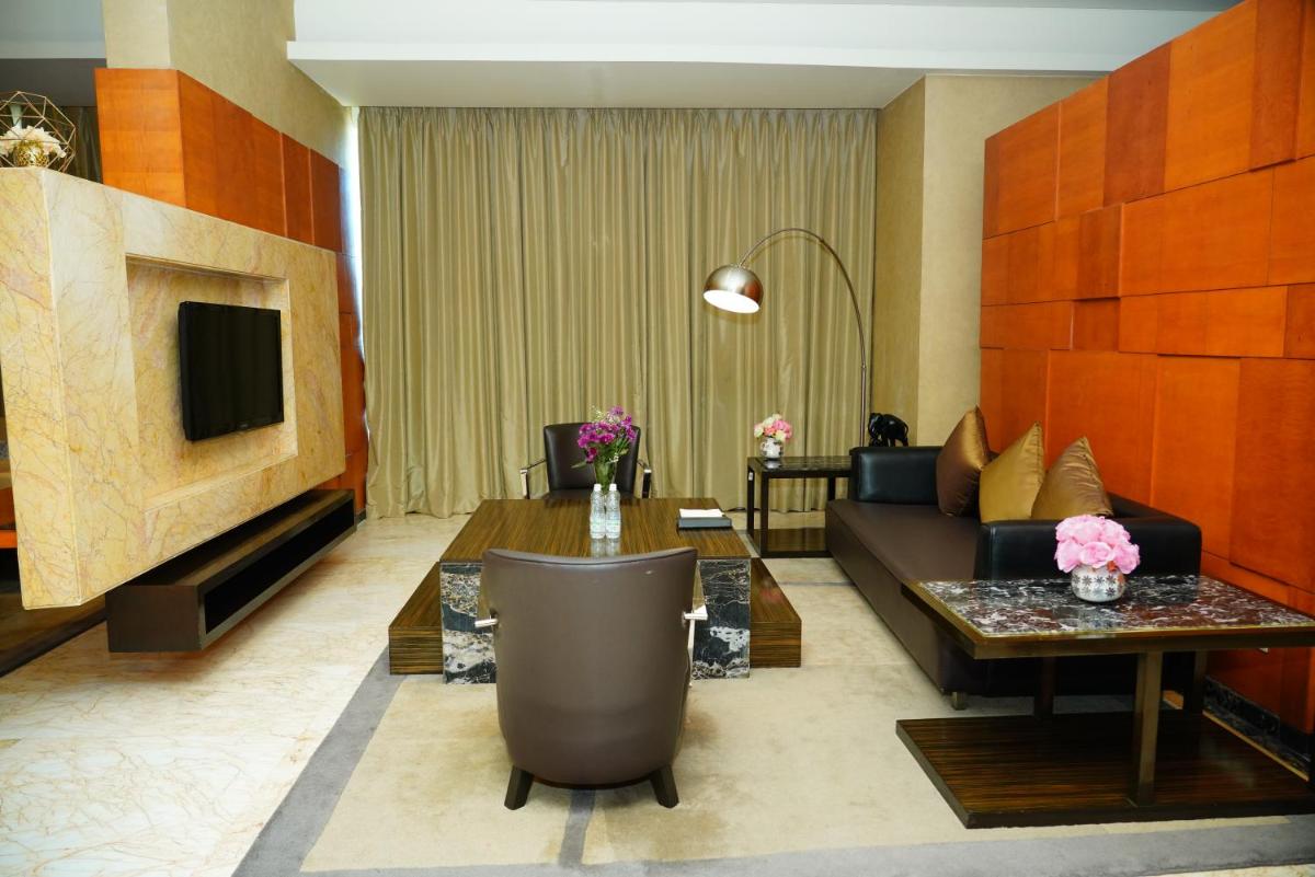 a living room with a couch and a table at Gokulam Grand Hotel & Spa Bangalore in Bengaluru a living room with a couch and a table at Gokulam Grand Hotel & Spa Bangalore in Bengaluru