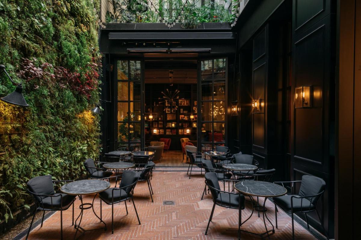 Un patio con mesas y sillas en un restaurante. en Wittmore Hotel - Adults Only, Small Luxury Hotels, en Barcelona