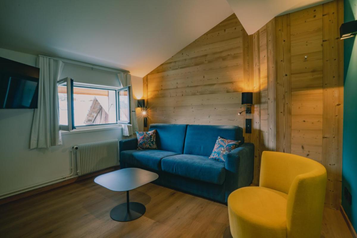un salon avec un canapé bleu et une chaise dans l'établissement Terra-Beka Lodge, à La Chapelle-dʼAbondance