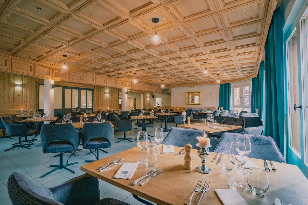 un restaurant avec des plafonds en bois, des tables et des chaises dans l'établissement Terra-Beka Lodge, à La Chapelle-dʼAbondance