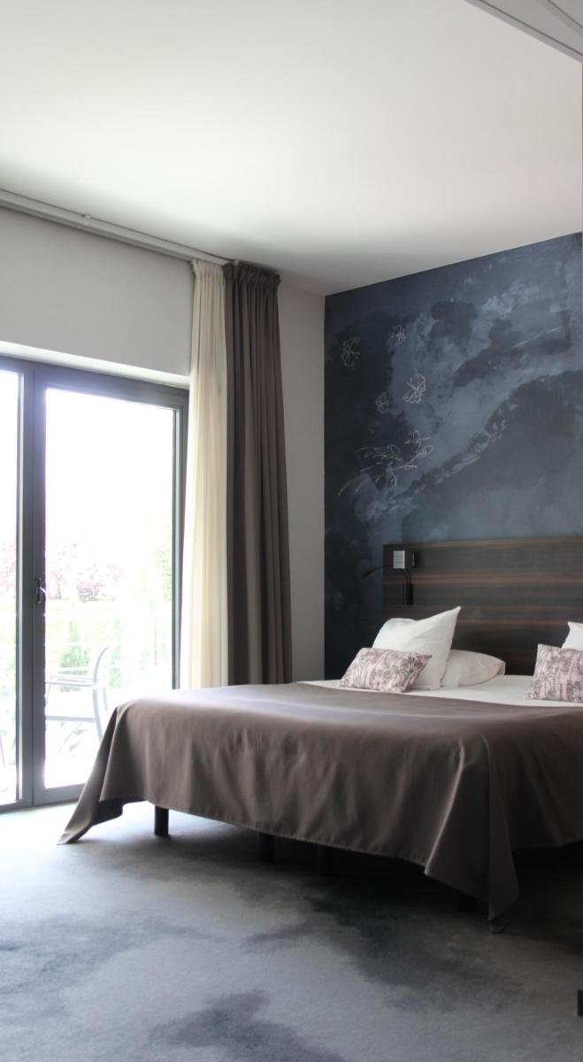 Un ou plusieurs lits dans un hébergement de l'établissement Logis Hôtel Victor Hugo & Spa
