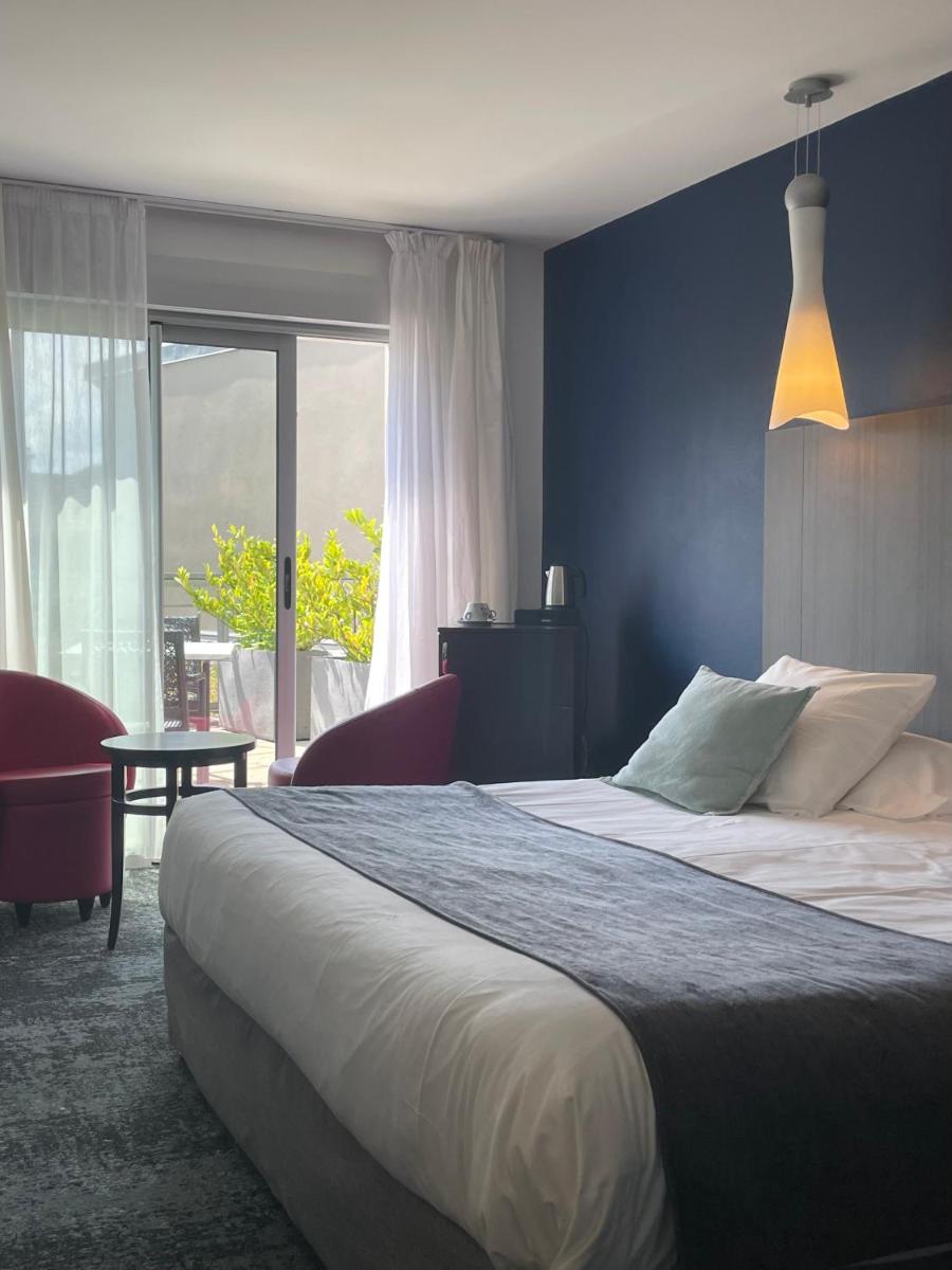 Un ou plusieurs lits dans un hébergement de l'établissement Logis Hôtel Victor Hugo & Spa