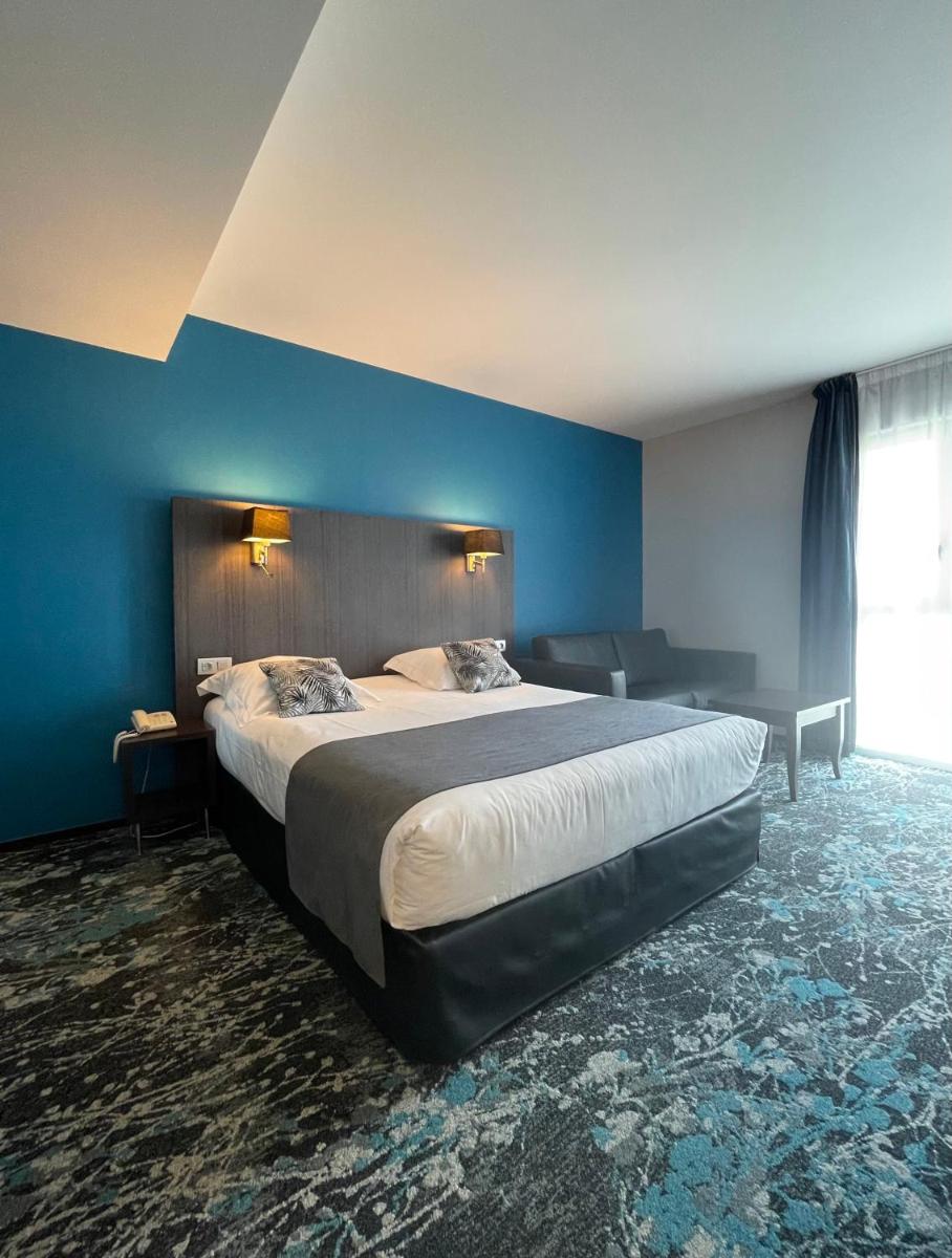 Un ou plusieurs lits dans un hébergement de l'établissement Logis Hôtel Victor Hugo & Spa