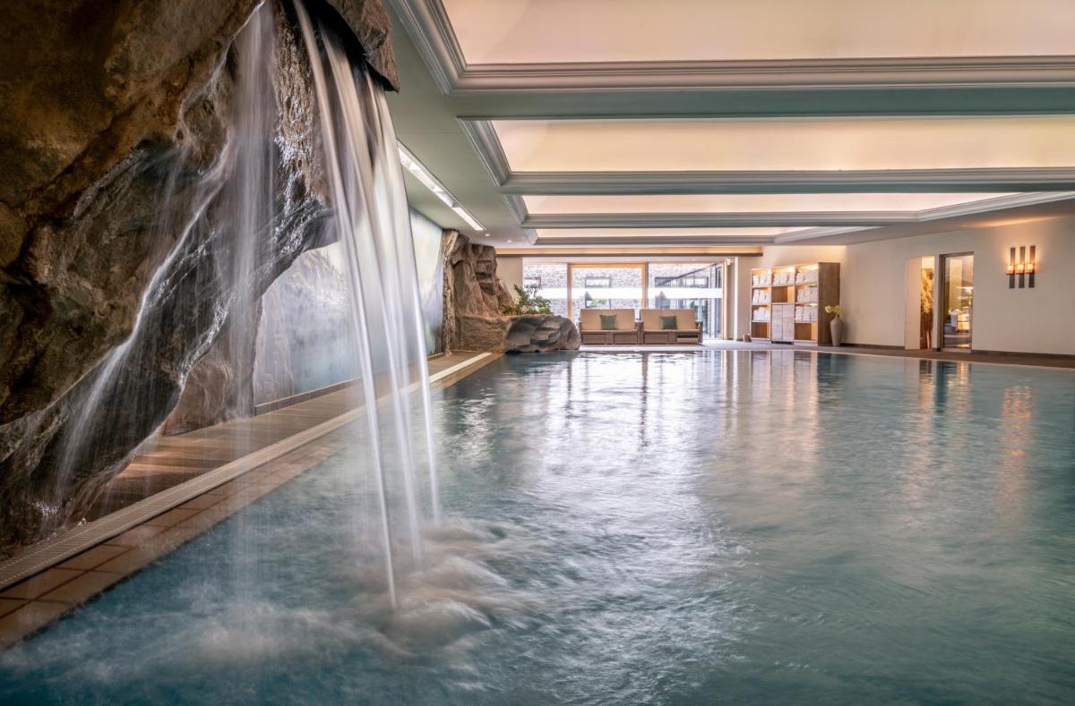 einen Pool mit Wasserfall in einem Hotelzimmer in der Unterkunft Hotel Franks in Oberstdorf