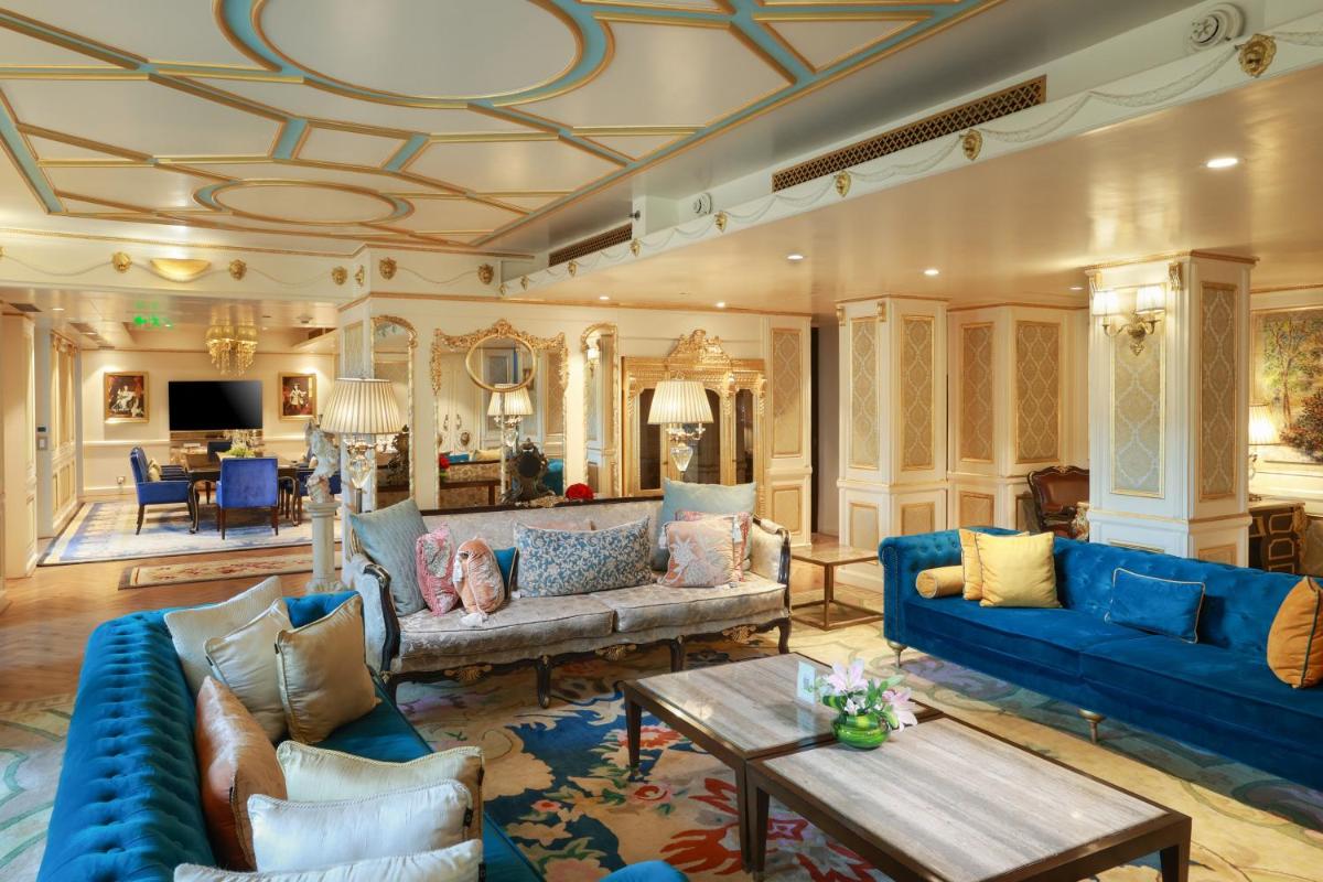 a living room with blue couches and a table at The Lodhi – A member of The Leading Hotels Of The World in New Delhi