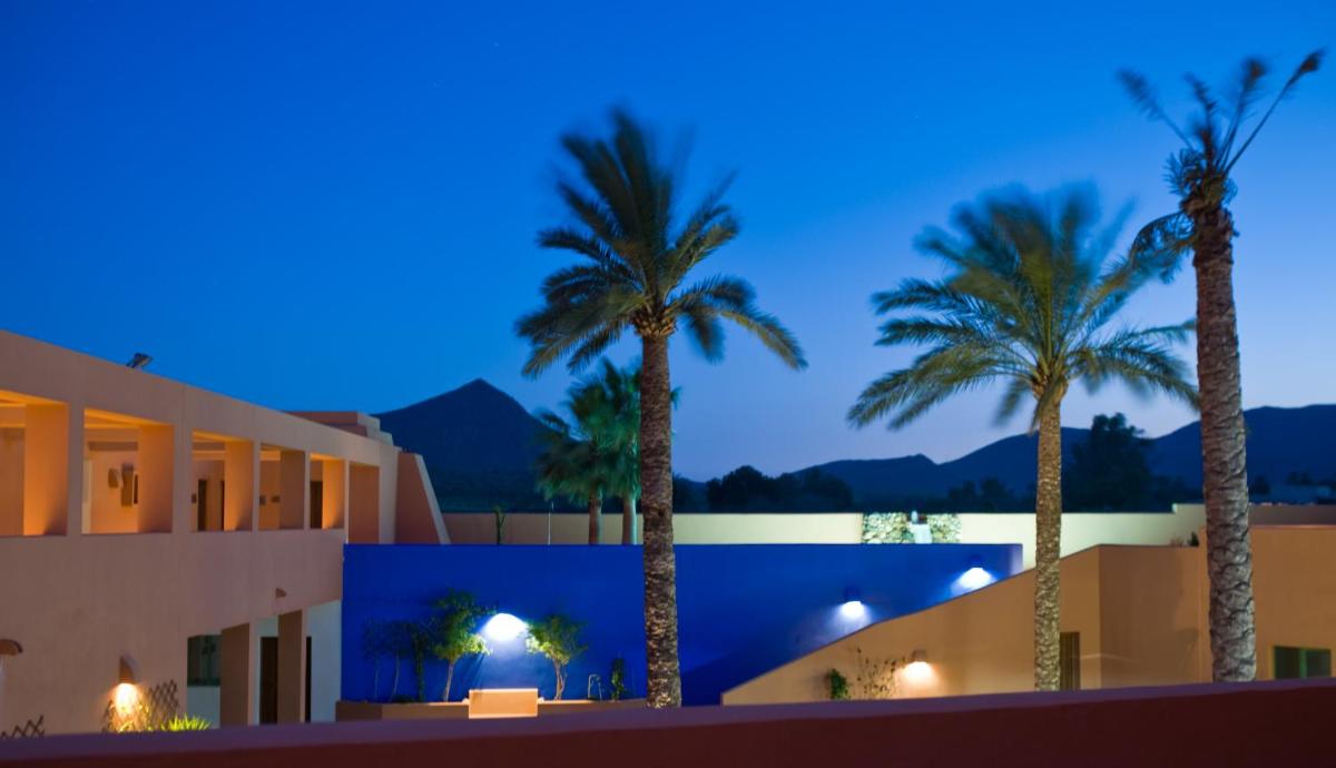 vistas a un edificio con palmeras por la noche en Hotel de Naturaleza Rodalquilar & Spa Cabo de Gata, en Rodalquilar