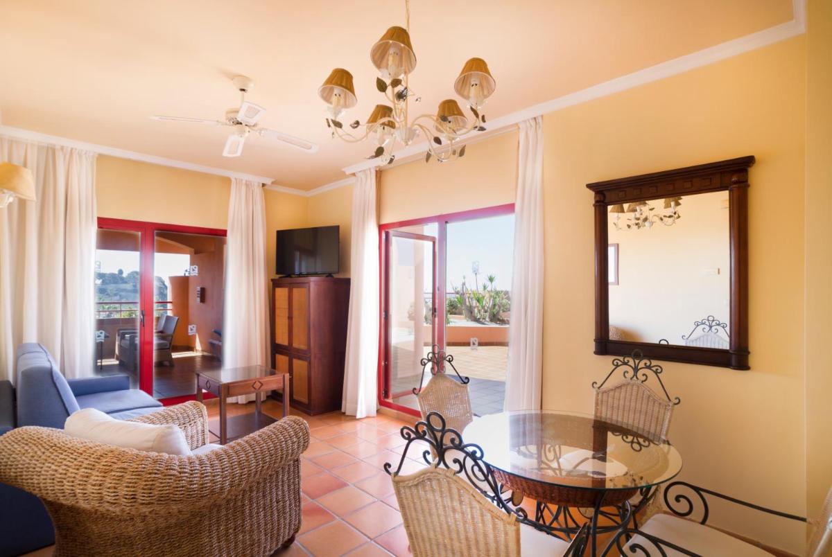 una sala de estar con una mesa y sillas en Ibersol Almuñecar Beach & Spa Hotel, en Almuñécar