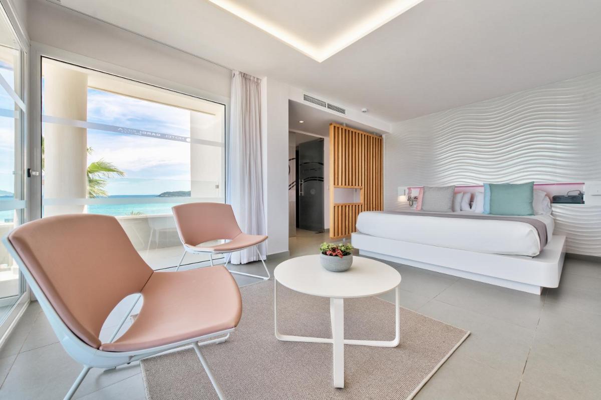 Un dormitorio con una cama y dos sillas y una mesa. en Hotel Garbi Ibiza & Spa, en Playa d'en Bossa