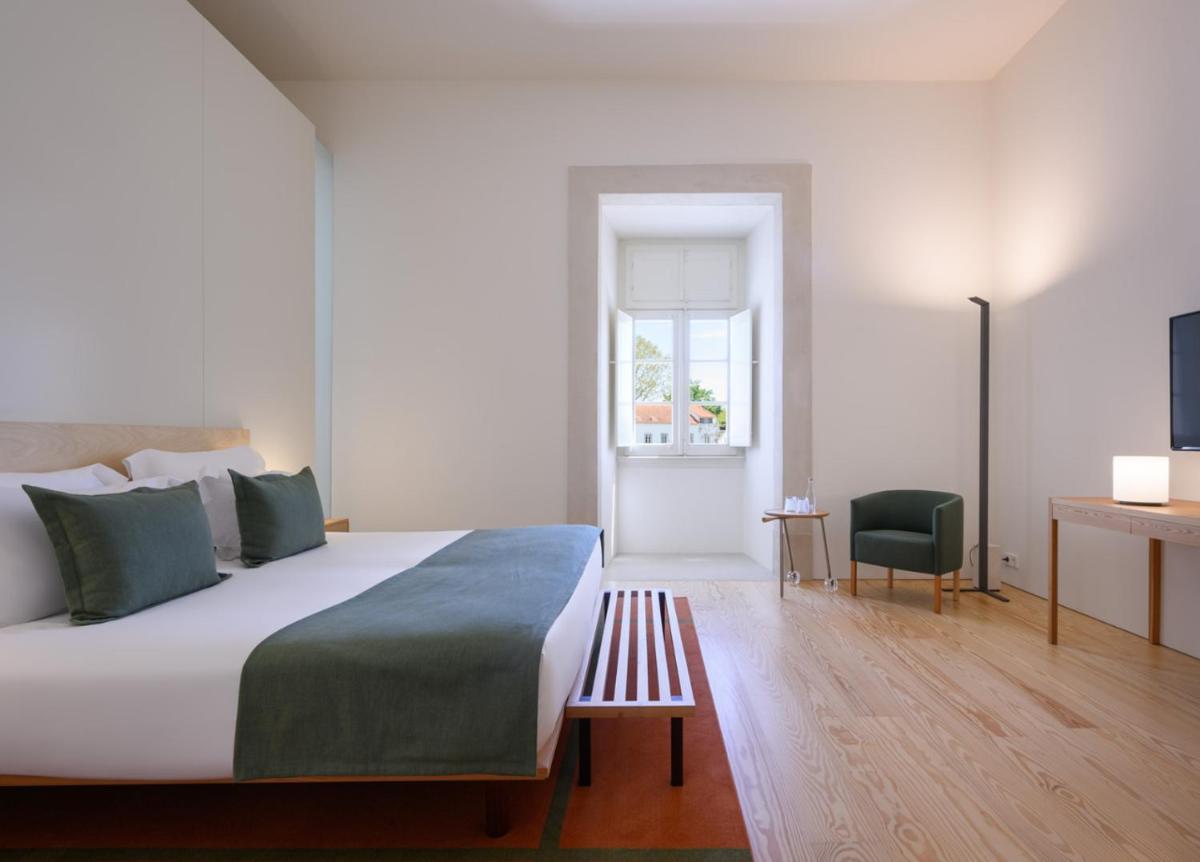 Uma cama ou camas num quarto em Montebelo Mosteiro de Alcobaça Historic Hotel
