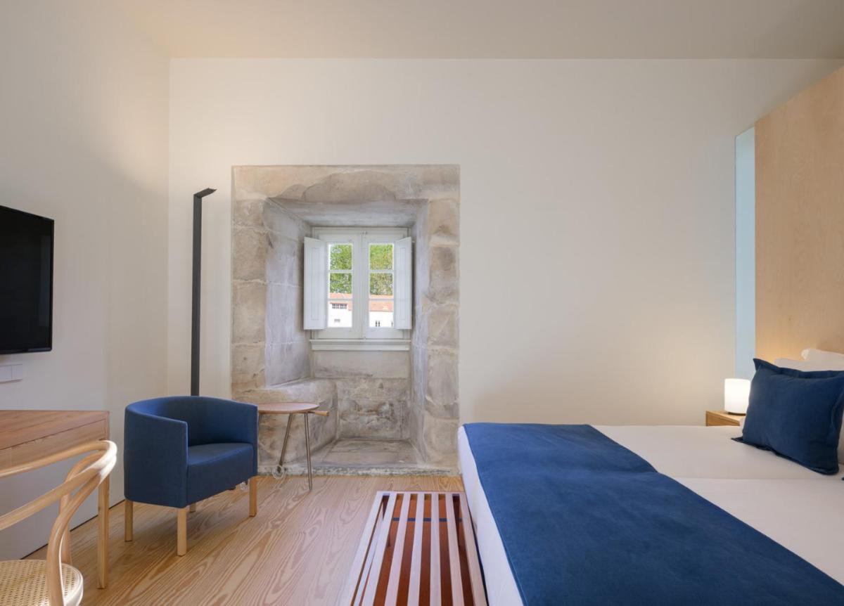 Uma cama ou camas num quarto em Montebelo Mosteiro de Alcobaça Historic Hotel