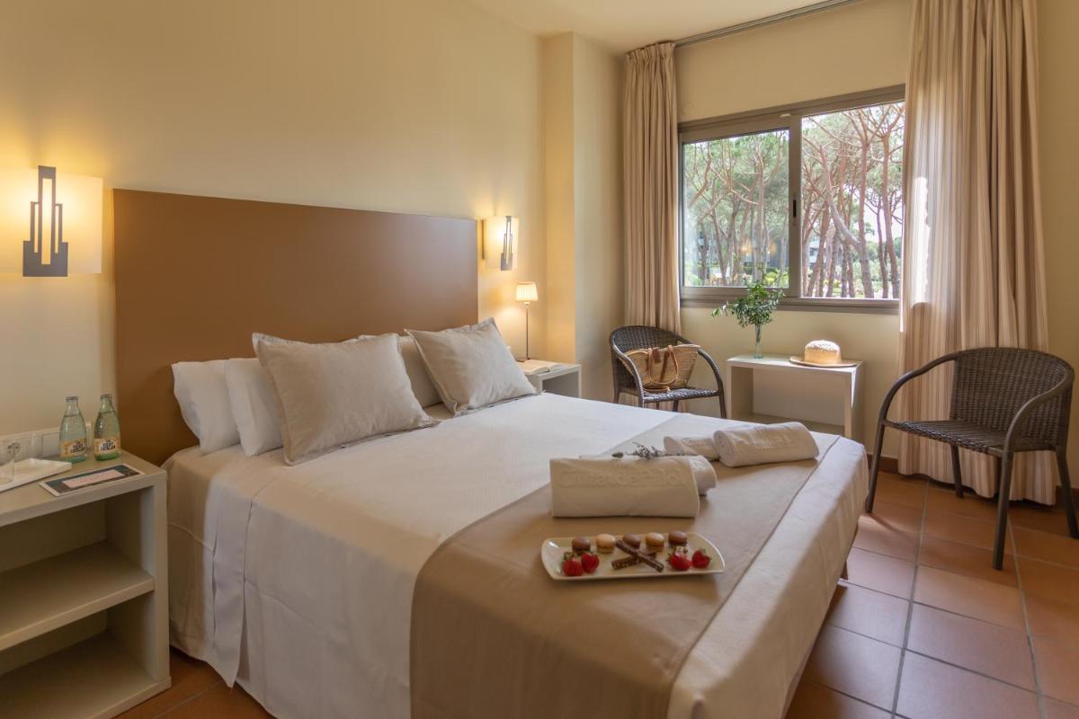 Habitación de hotel con cama grande y bandeja de comida. en Aparthotel Ciutat de Palol, en Platja d'Aro