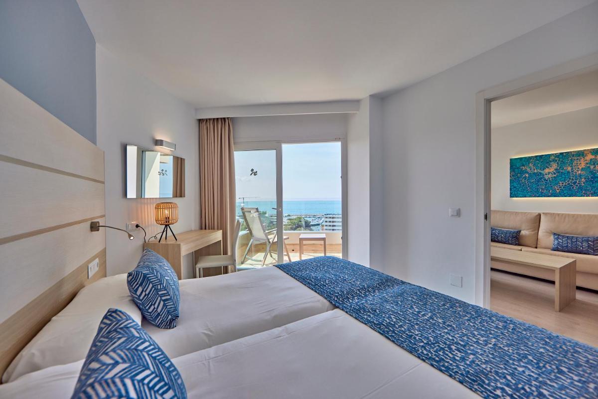Un dormitorio con una cama y vista al mar. en Tomir Portals Suites - Adults Only, en Portals Nous