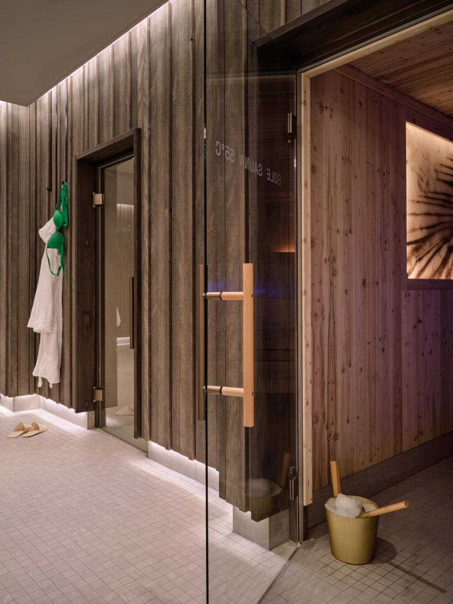 ein Badezimmer mit Holzwänden und einer Glastür in der Unterkunft the breeze in Ahlbeck