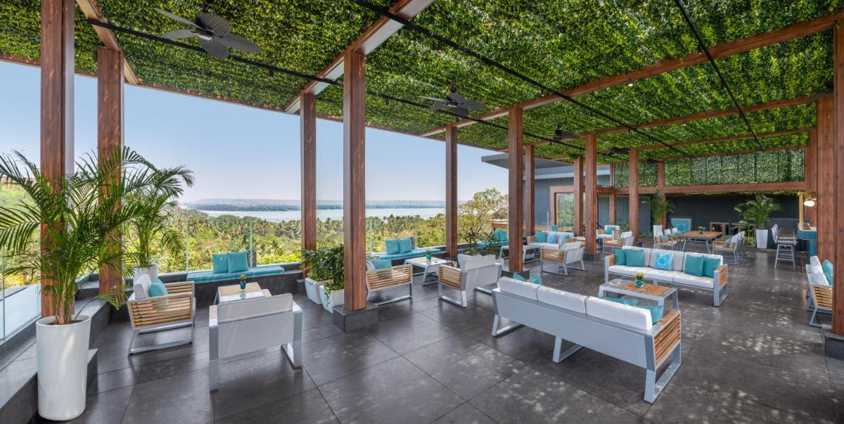 a pavilion with chairs and tables with a view of the ocean at JW Marriott Goa in Vagator a pavilion with chairs and tables with a view of the ocean at JW Marriott Goa in Vagator