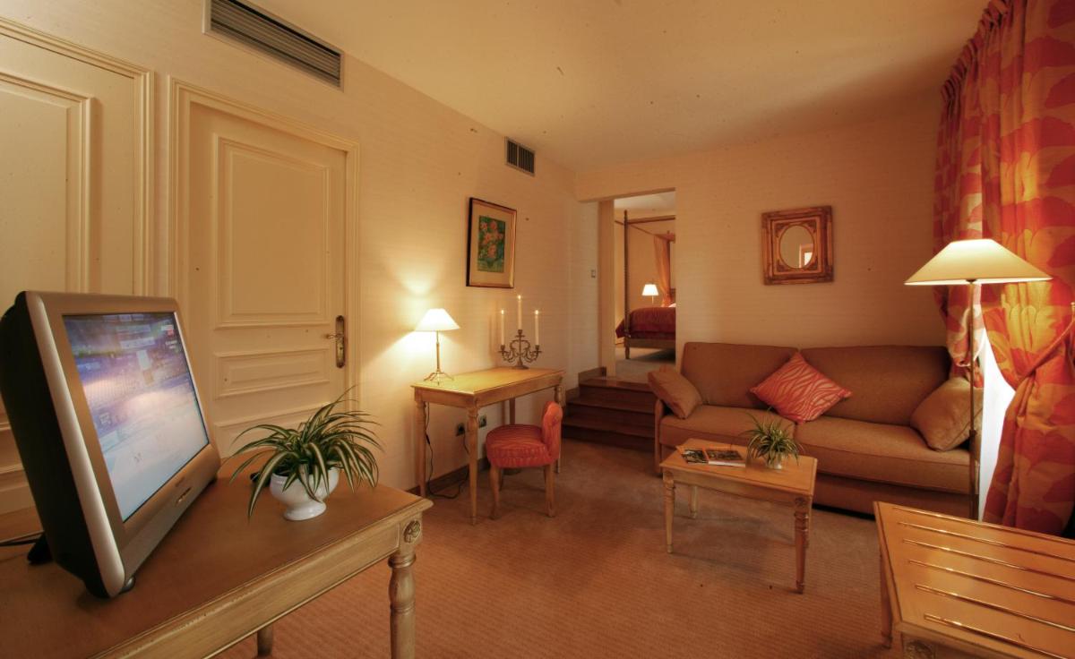 un salon avec un canapé et une télévision dans l'établissement Clos La Boëtie & Spa, à Sarlat-la-Canéda