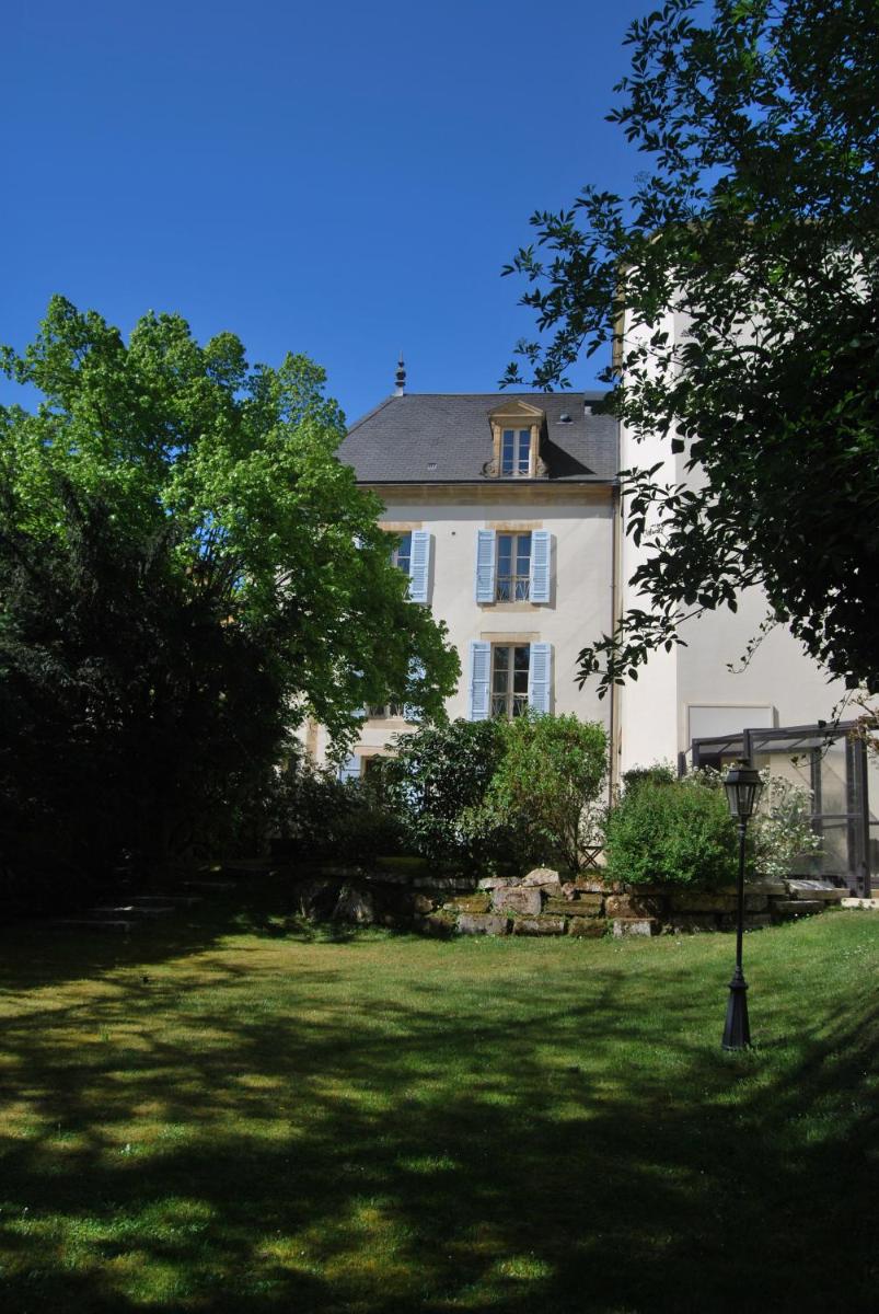 une grande maison blanche avec un arbre dans la cour dans l'établissement Clos La Boëtie & Spa, à Sarlat-la-Canéda