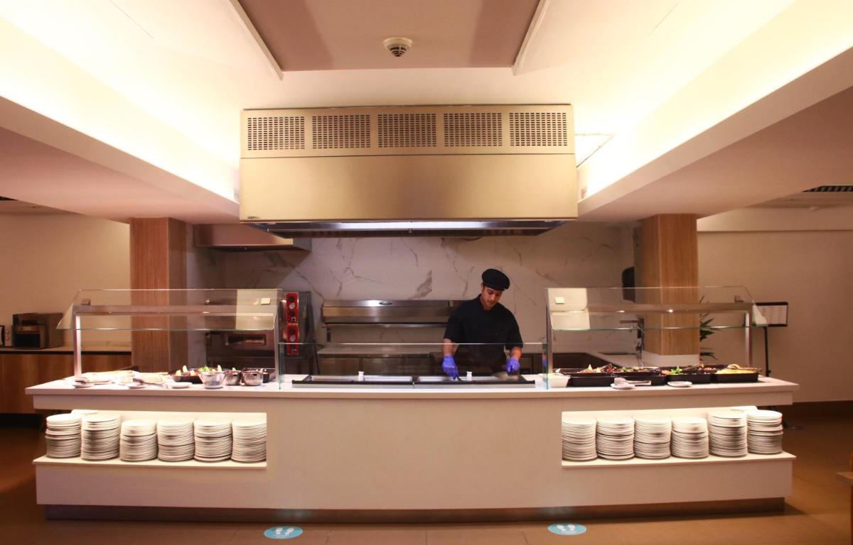 un hombre de pie en una cocina preparando comida en Tossa Beach Center, en Tossa de Mar 25 fotos más