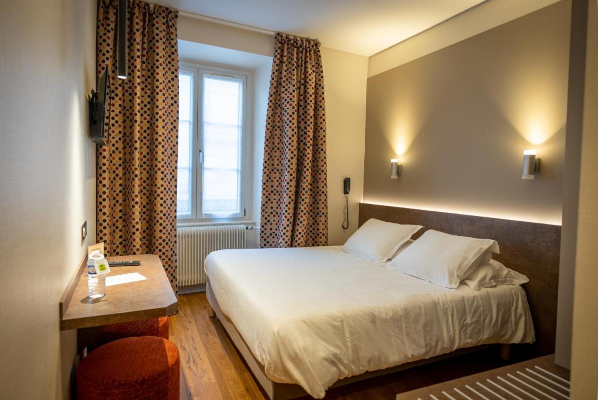 Un ou plusieurs lits dans un hébergement de l'établissement Logis Hôtel de la Tour