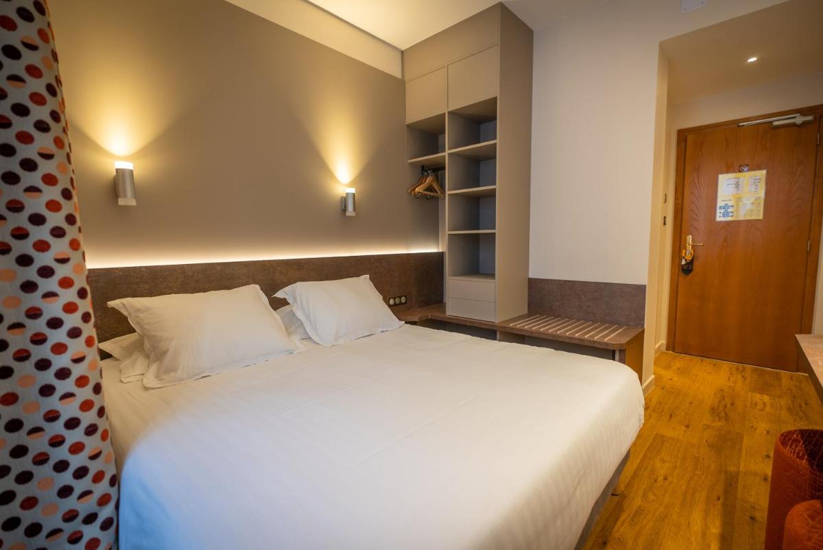 Un ou plusieurs lits dans un hébergement de l'établissement Logis Hôtel de la Tour