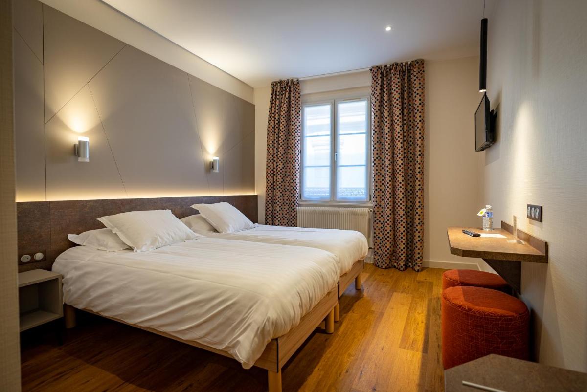 Un ou plusieurs lits dans un hébergement de l'établissement Logis Hôtel de la Tour