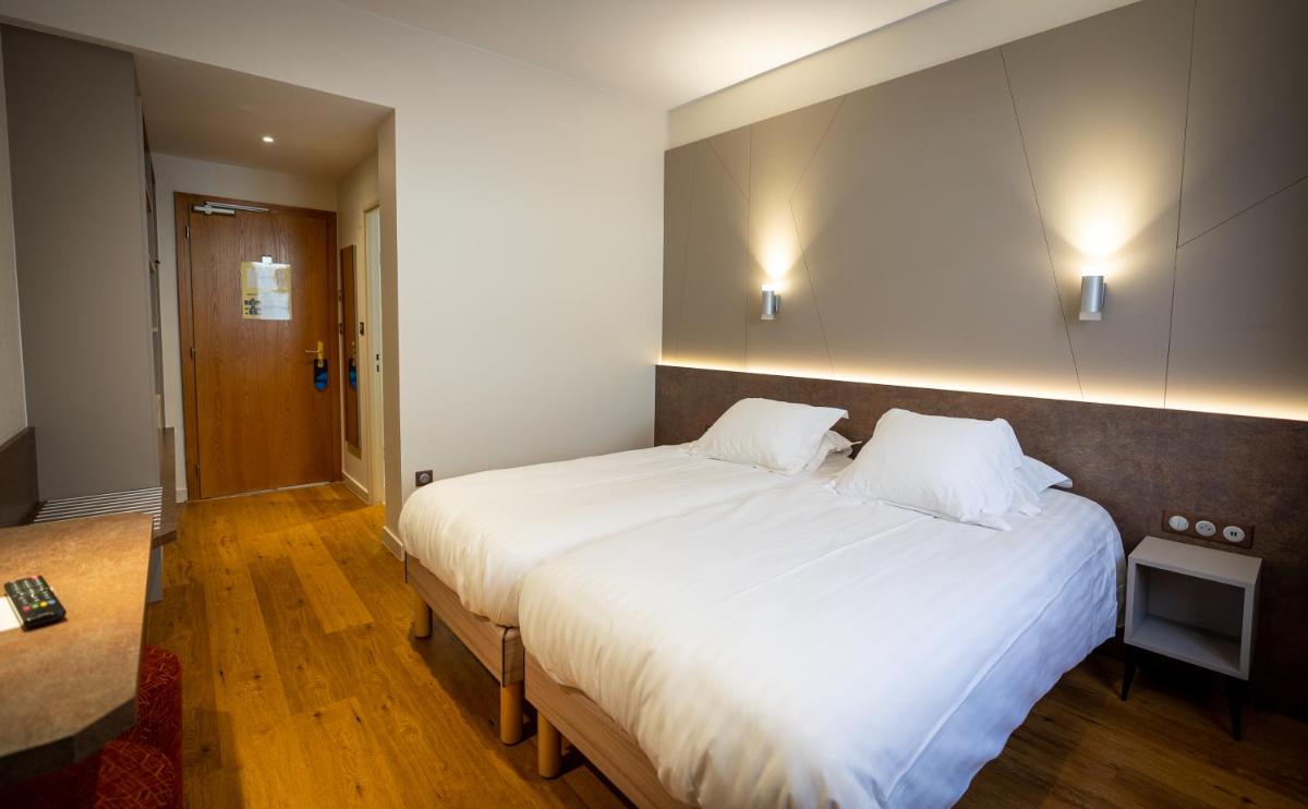 Un ou plusieurs lits dans un hébergement de l'établissement Logis Hôtel de la Tour