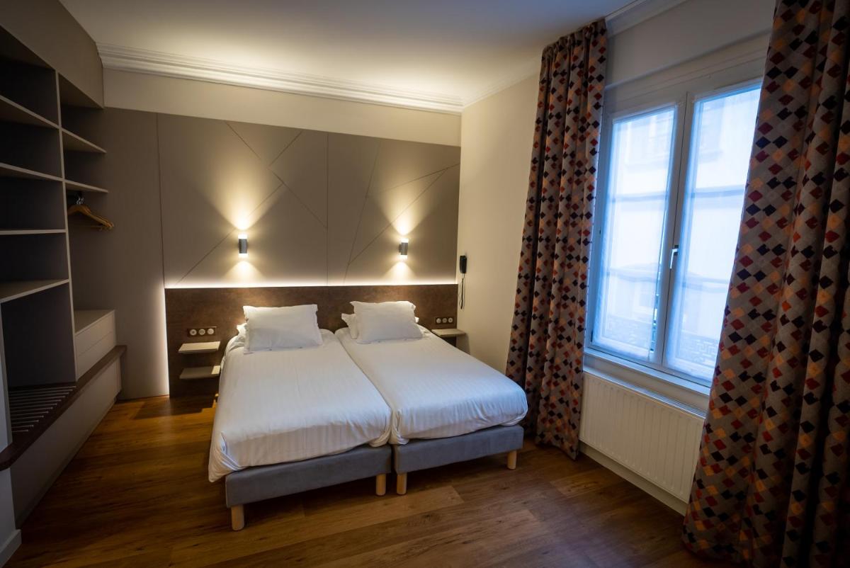 Un ou plusieurs lits dans un hébergement de l'établissement Logis Hôtel de la Tour