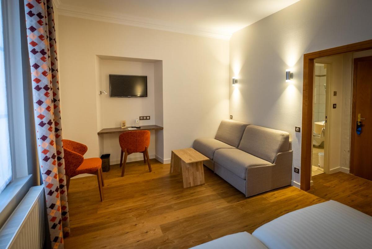 Télévision ou salle de divertissement dans l'établissement Logis Hôtel de la Tour