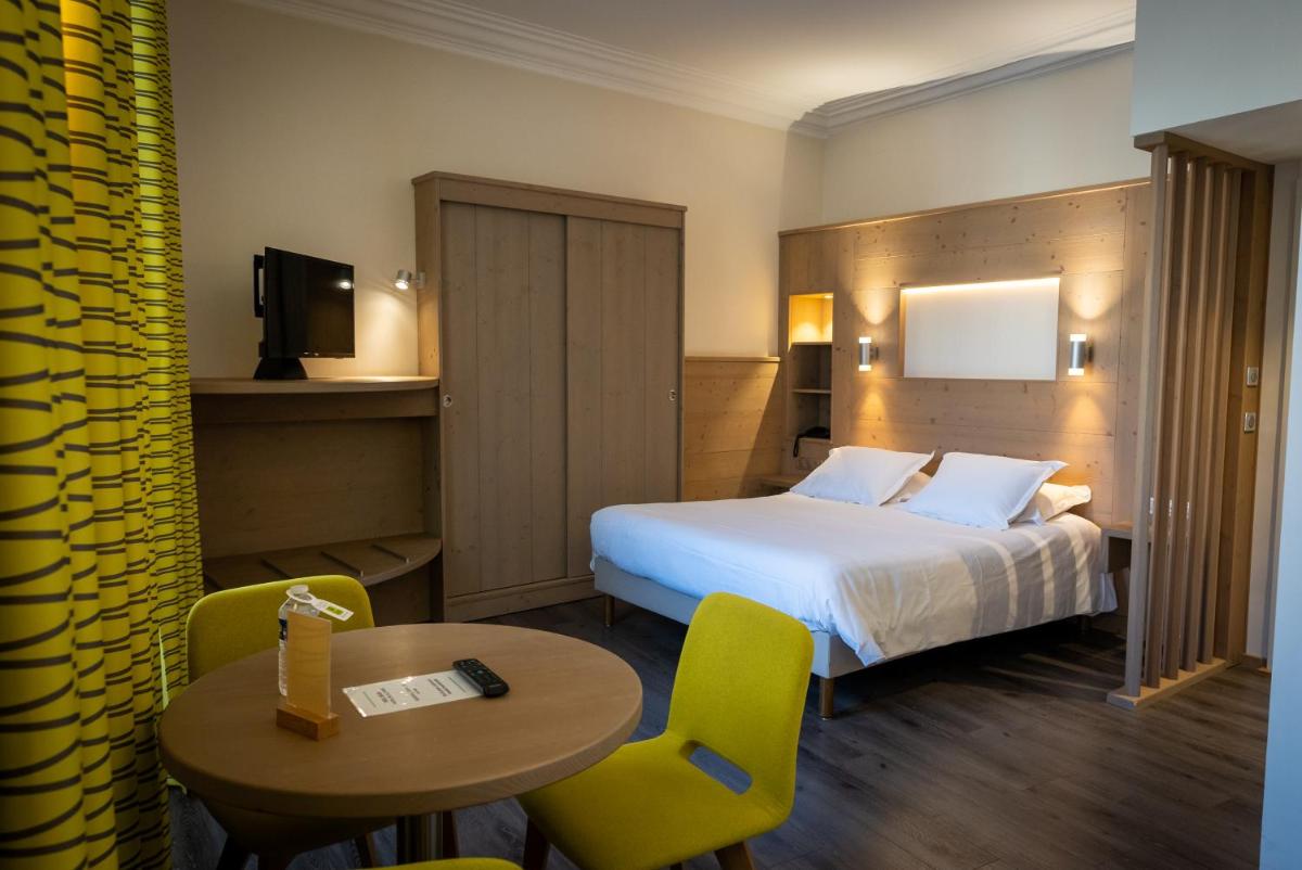 Un ou plusieurs lits dans un hébergement de l'établissement Logis Hôtel de la Tour