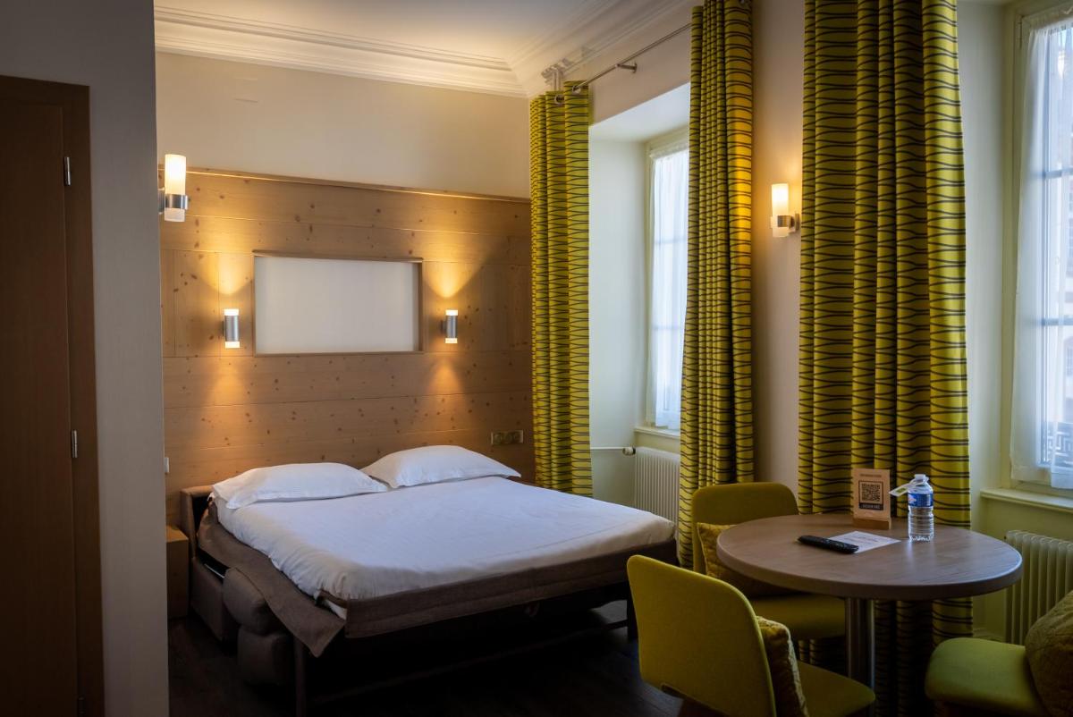 Un ou plusieurs lits dans un hébergement de l'établissement Logis Hôtel de la Tour