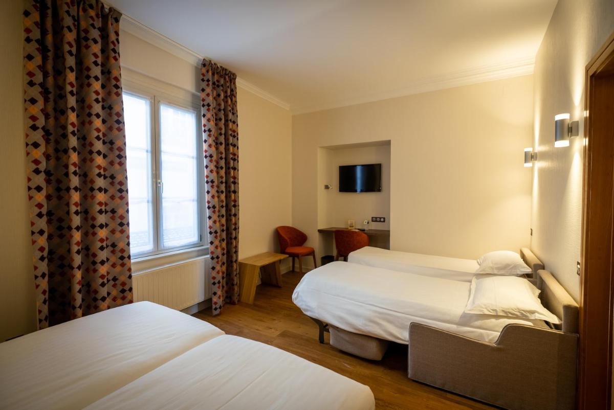 Un ou plusieurs lits dans un hébergement de l'établissement Logis Hôtel de la Tour