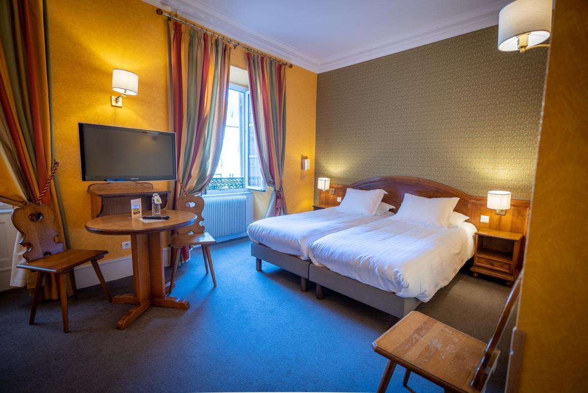 Un ou plusieurs lits dans un hébergement de l'établissement Logis Hôtel de la Tour