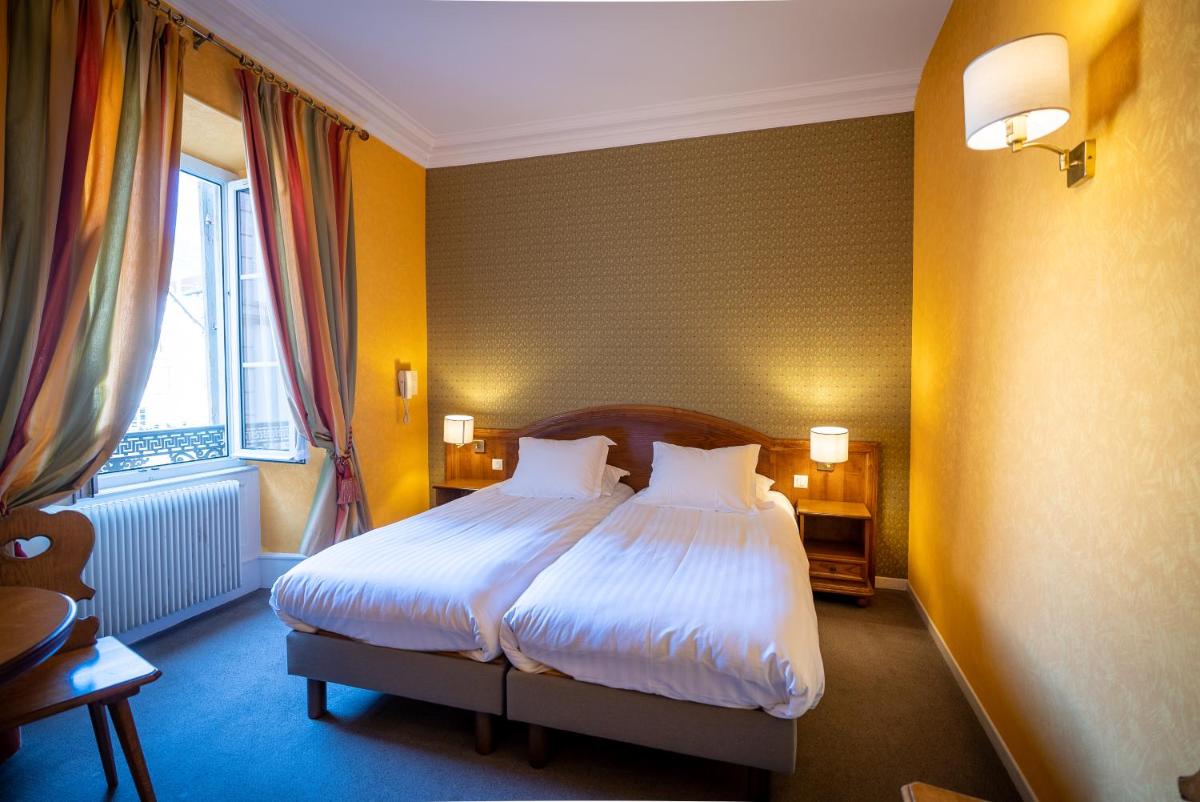 Un ou plusieurs lits dans un hébergement de l'établissement Logis Hôtel de la Tour