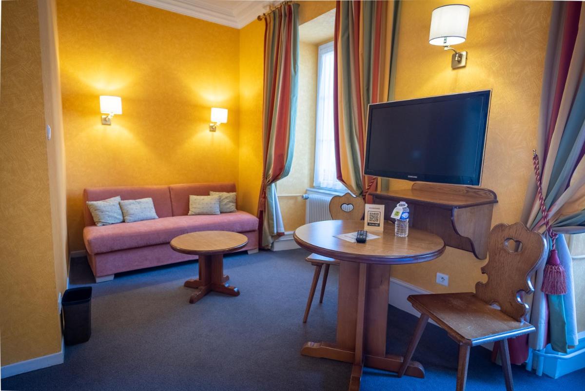 Télévision ou salle de divertissement dans l'établissement Logis Hôtel de la Tour