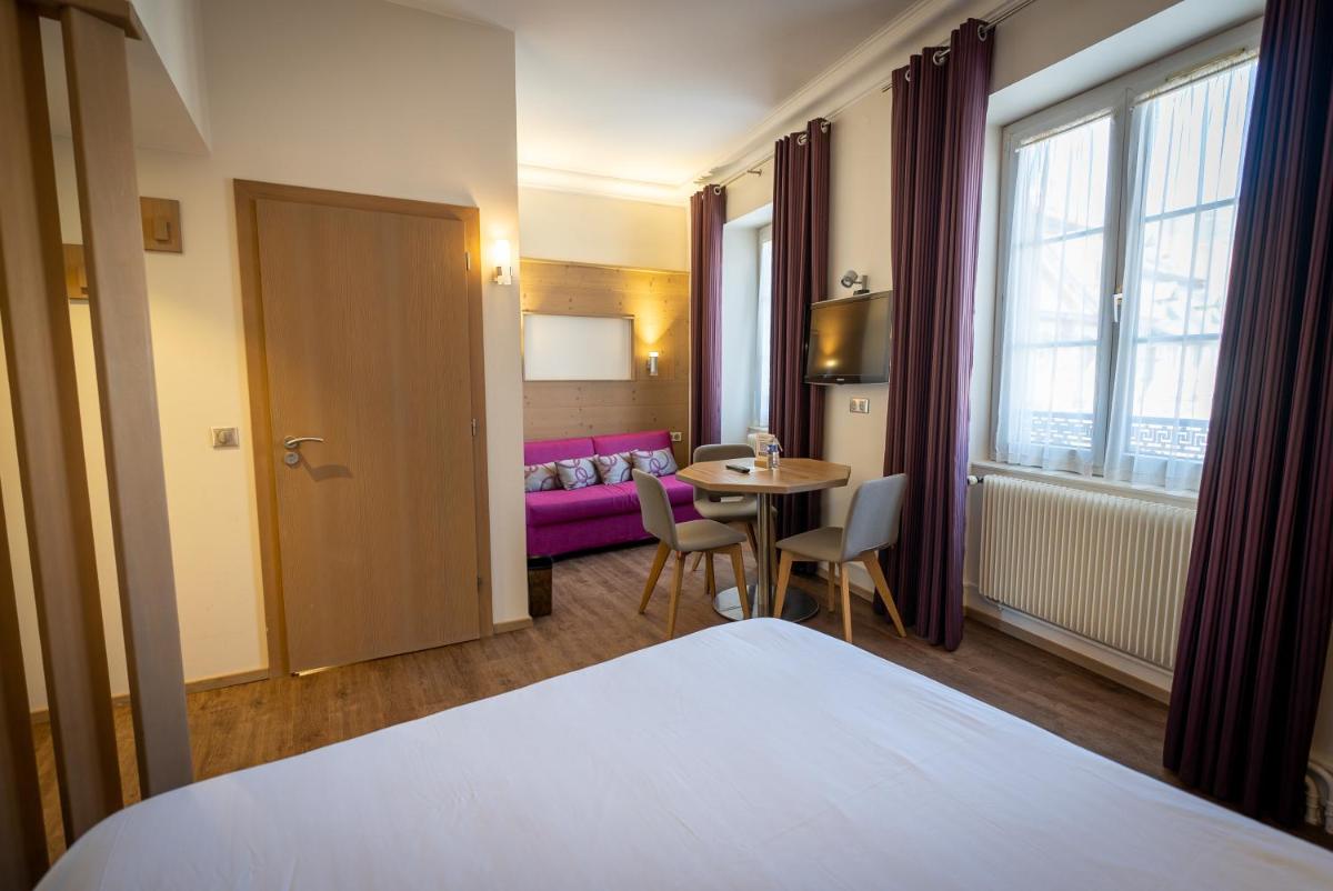 Un ou plusieurs lits dans un hébergement de l'établissement Logis Hôtel de la Tour