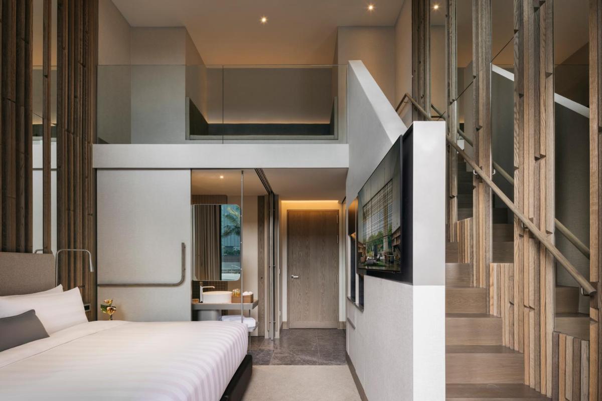 a bedroom with a bed and a staircase in a room at Pan Pacific Orchard in Singapore