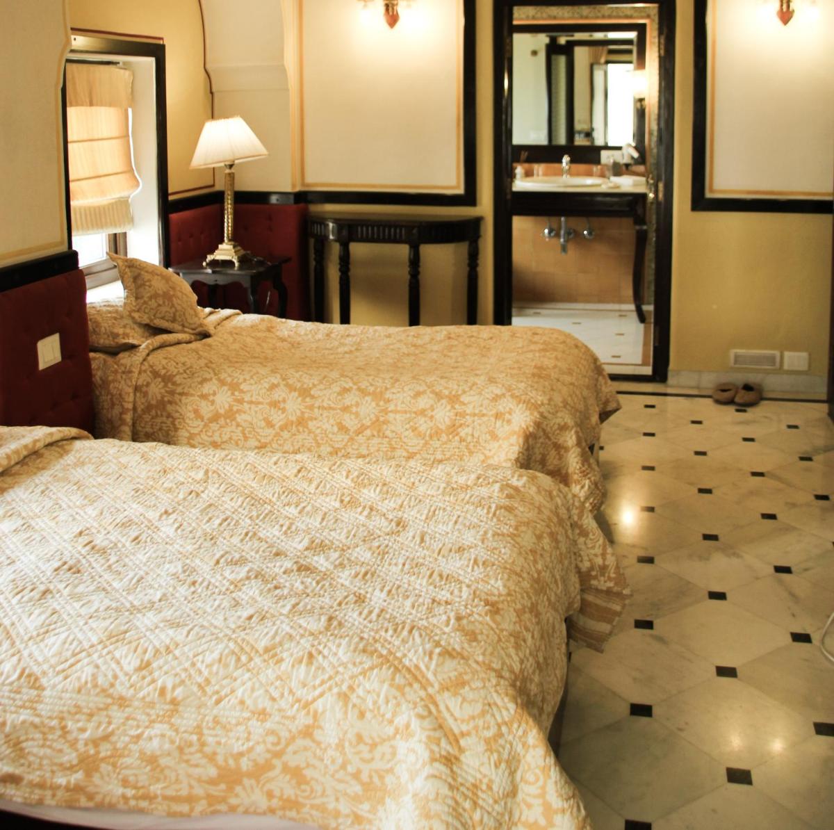 a bedroom with a bed and a bathroom with a mirror at Royal Heritage Haveli - By Leisure Hotels in Jaipur