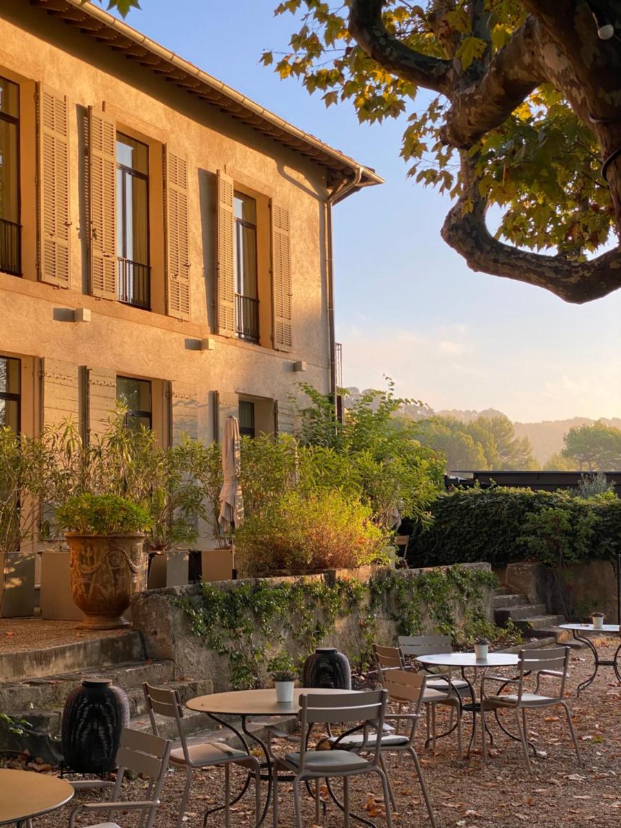 un groupe de tables et de chaises devant un bâtiment dans l'établissement Les Lodges Sainte-Victoire Hotel & Spa, à Aix-en-Provence