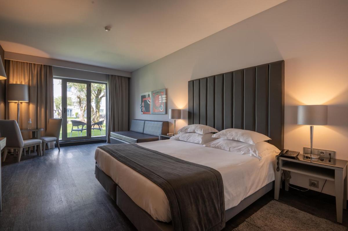 um quarto com uma cama grande com uma cabeceira grande em Vila Gale Evora em Évora