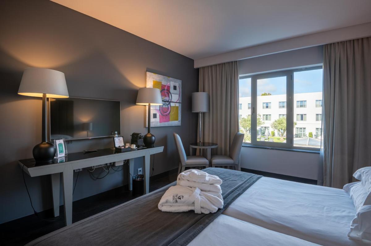Uma cama ou camas num quarto em Vila Gale Evora