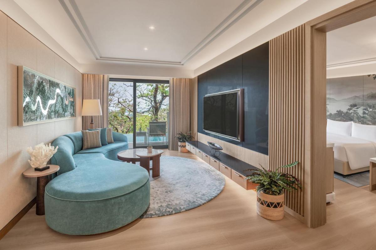a living room with a blue couch and a tv at JW Marriott Goa in Vagator a living room with a blue couch and a tv at JW Marriott Goa in Vagator