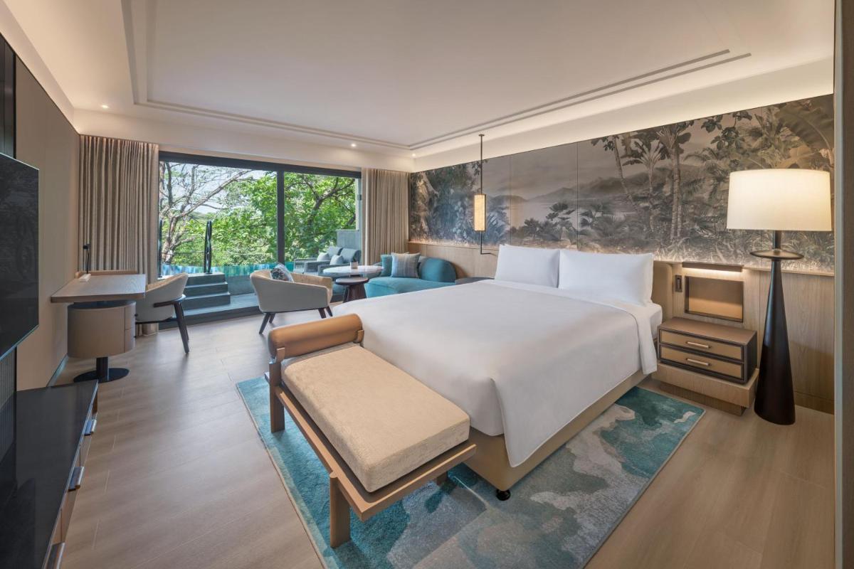 a bedroom with a large bed and a living room at JW Marriott Goa in Vagator a bedroom with a large bed and a living room at JW Marriott Goa in Vagator