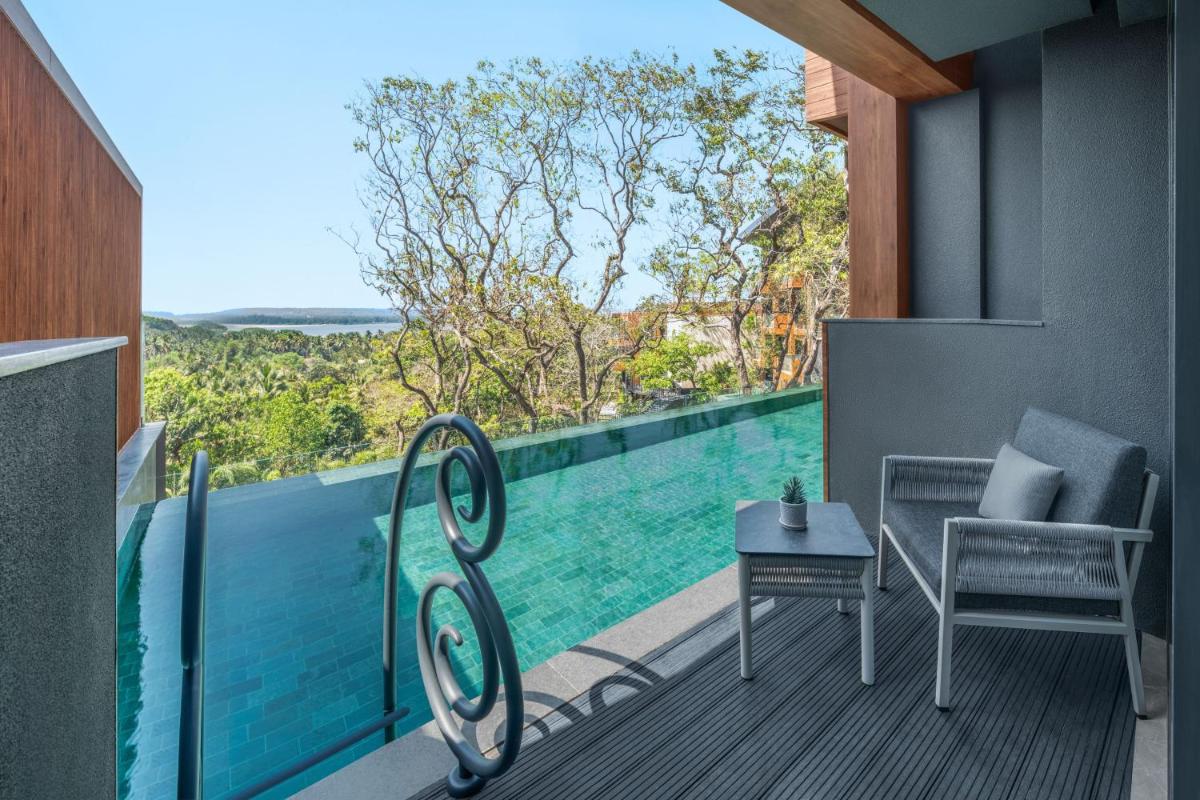 a balcony with a view of a swimming pool at JW Marriott Goa in Vagator a balcony with a view of a swimming pool at JW Marriott Goa in Vagator