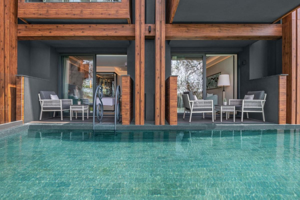 a house with a swimming pool with chairs and tables at JW Marriott Goa in Vagator a house with a swimming pool with chairs and tables at JW Marriott Goa in Vagator